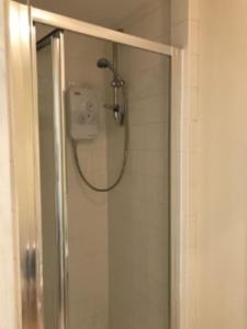 a shower in a bathroom with a glass door at Hillfields Farm Barn - A Rural Equestrian Escape in Coventry