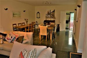 a living room with a couch and a dining room at Hillfields Farm Barn - A Rural Equestrian Escape in Coventry
