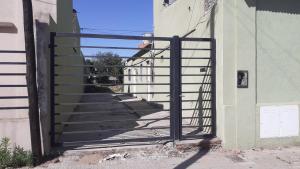 a gate leading to a stairway with a railing at Depto centro in Tres Arroyos