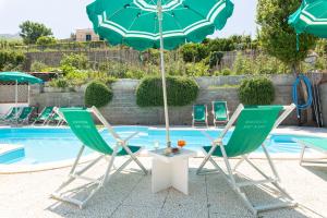 two chairs and an umbrella next to a pool at Residence Villa Tina in Ischia