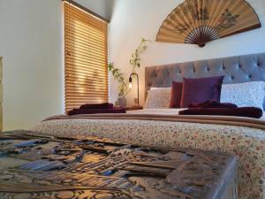 a bedroom with a large bed with a large headboard at Eden on Young Street in Wayville