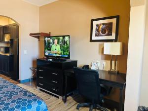 Habitación con escritorio, TV y ordenador. en Executive Inn & Suites, en Floresville