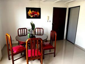un comedor con mesa, sillas y una pintura en Apartamento Nuevo, Amplio, Iluminado, Tranquilo, Acogedor., en Popayán
