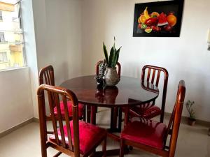 a dining room table and chairs with a vase on it at Apartamento Nuevo, Amplio, Iluminado, Tranquilo, Acogedor. in Popayan