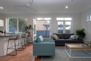 ein Wohnzimmer mit Sofa und Tisch in der Unterkunft Morris Cottage Cumberland Park in Colonel Light Gardens