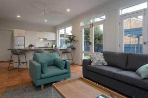 ein Wohnzimmer mit Couch und Küche in der Unterkunft Morris Cottage Cumberland Park in Colonel Light Gardens