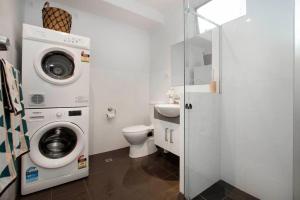 ein Badezimmer mit einer Waschmaschine und einem WC in der Unterkunft Boho on Sussex North Adelaide in Adelaide