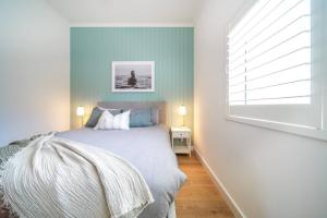 a bedroom with a bed with blue walls and a window at The Retreat Plympton in Plympton