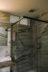 a shower with a glass door in a bathroom at Redwalls Lodge in Cajamarca