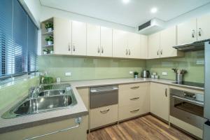 a kitchen with white cabinets and a sink at Emerald on Gover Street in Bowden