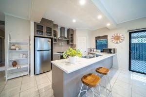 a kitchen with a large island with two stools at Gone Coastal Grange in Grange