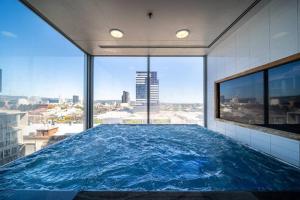 una gran piscina en un edificio con una gran ventana en Relax Balfours Way Adelaide, en Adelaida