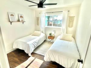 Duas camas num quarto branco com uma janela em Peaceful Canyon Retreat em San Diego