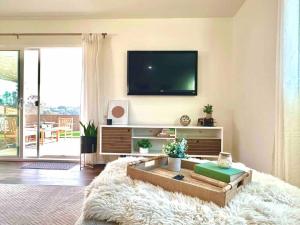 a living room with a flat screen tv on a wall at Peaceful Canyon Retreat in San Diego