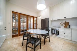 a kitchen with a table and chairs and a refrigerator at Netley Cottage Eastwood in Rose Park