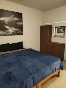 1 dormitorio con 1 cama y una pintura en la pared en Hospedaje La Gloria, en Texcoco de Mora