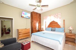 una camera da letto con un letto grande e un divano di Cozy Locale - Gold a Port Antonio