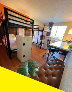 a bedroom with bunk beds and a desk and a table at Bposhtels Charlotte in Charlotte