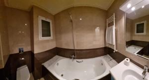 a bathroom with a tub and a shower and a sink at Perle du Lac in Tunis