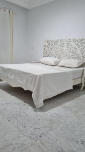 a white bed with white sheets and pillows on it at Perle du Lac in Tunis