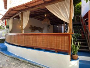 a house with a brick wall and a balcony at Pousada Ilha De Boipeba in Ilha de Boipeba