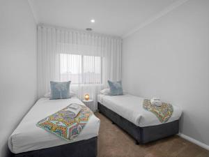 a bedroom with two beds and a window at Clio on the corner in Shepparton