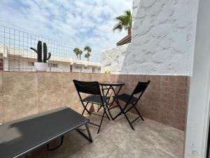 a patio with two chairs and a table on a balcony at Practical and cozy apartment in southern Arona in Arona