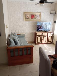 Zimmer mit einem Bett mit Kissen und einem TV in der Unterkunft MRU Colón aparts in Colón