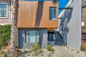 dom z drewnianą fasadą i palmą w obiekcie Silicon Valley Stay Apartments w mieście San Carlos