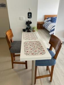 a dining room table with two chairs and a bed at APARTAMENTO FAMILIAR EN PAIPA RÚSTlCO 70-9 in Paipa +32 photos