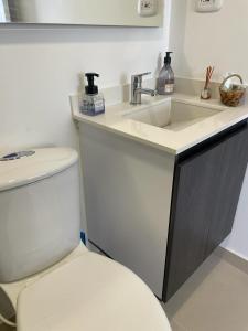 ein Badezimmer mit einem weißen WC und einem Waschbecken in der Unterkunft PAIPA APARTAESTUDIO LUXURY EDIFICIO RUSTICO 70-9 Apto 706 in Paipa