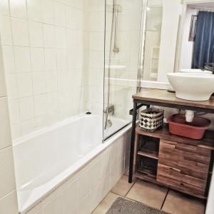 uma casa de banho com uma banheira e um lavatório em L'Oxalys Studio ! Coin montagne - Pied des pistes & Centre ville em Briançon