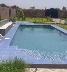 una gran piscina de agua azul en un patio en Villa avec piscine ( régions de Marrakech), 