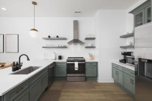 eine Küche mit grünen Schränken und einem Waschbecken in der Unterkunft Trendy Spacious Condo, Walk to Coffee and Restaurants in Nashville + 36 Fotos