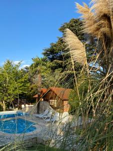 uma casa com piscina e algumas árvores em Cabaña Las dos Marías em Sierra de los Padres