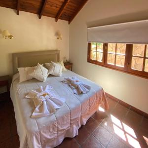 um quarto com uma cama com toalhas em Cabaña Las dos Marías em Sierra de los Padres