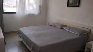 a bedroom with a bed with two pillows on it at Caleta in Acapulco