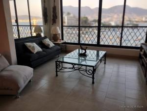 a living room with a couch and a glass table at Caleta in Acapulco