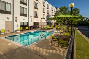 a pool with chairs and a table with an umbrella at SpringHill Suites by Marriott Lynchburg Airport/University Area in Lynchburg