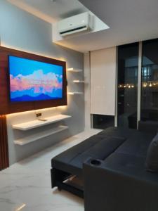 a living room with a flat screen tv on a wall at AZURE Residences Beach Front Living in the Heart of the City - Under New Management in Manila