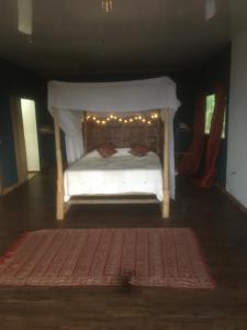 Un dormitorio con una cama blanca con luces. en VISTA CARIBE en Portobelo