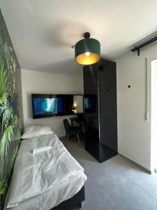 a bedroom with a bed and a tv on the wall at EasyLiving Darmstadt in Darmstadt