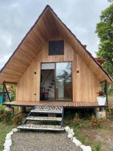 a small wooden house with a large window and stairs at Myra Chalets in Bijagua