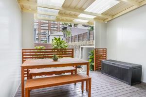 a patio with a bench and a table and a heater at Surry Hills l 2 Bedroom Terrace Home in Sydney