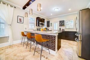 a kitchen with a large island with orange bar stools at Southtown Downtown Home Walk to Riverwalk in San Antonio