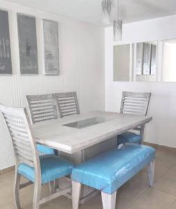 uma mesa de jantar com 2 cadeiras e uma mesa com assentos azuis em Casa cómoda para descansar o vacacionar em Xochitepec
