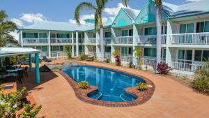 a swimming pool in front of a building at Reef Adventureland Motor Inn in Tannum Sands