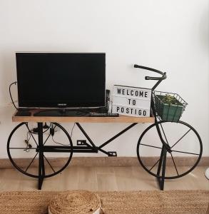 ein Fernseher auf einem Tisch mit einem Fahrrad darauf in der Unterkunft O POSTIGO in Praia da Vitória