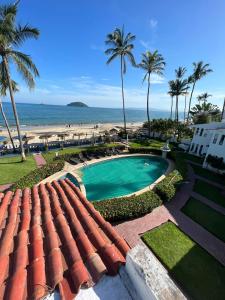 a view of a swimming pool and the beach at HOTEL VILLAS EL DORADO in Rincon de Guayabitos