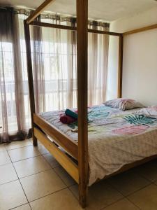- une chambre avec des lits superposés en bois et des rideaux dans l'établissement Chambre d'Hôtes Coconut Marina du Gosier, au Gosier